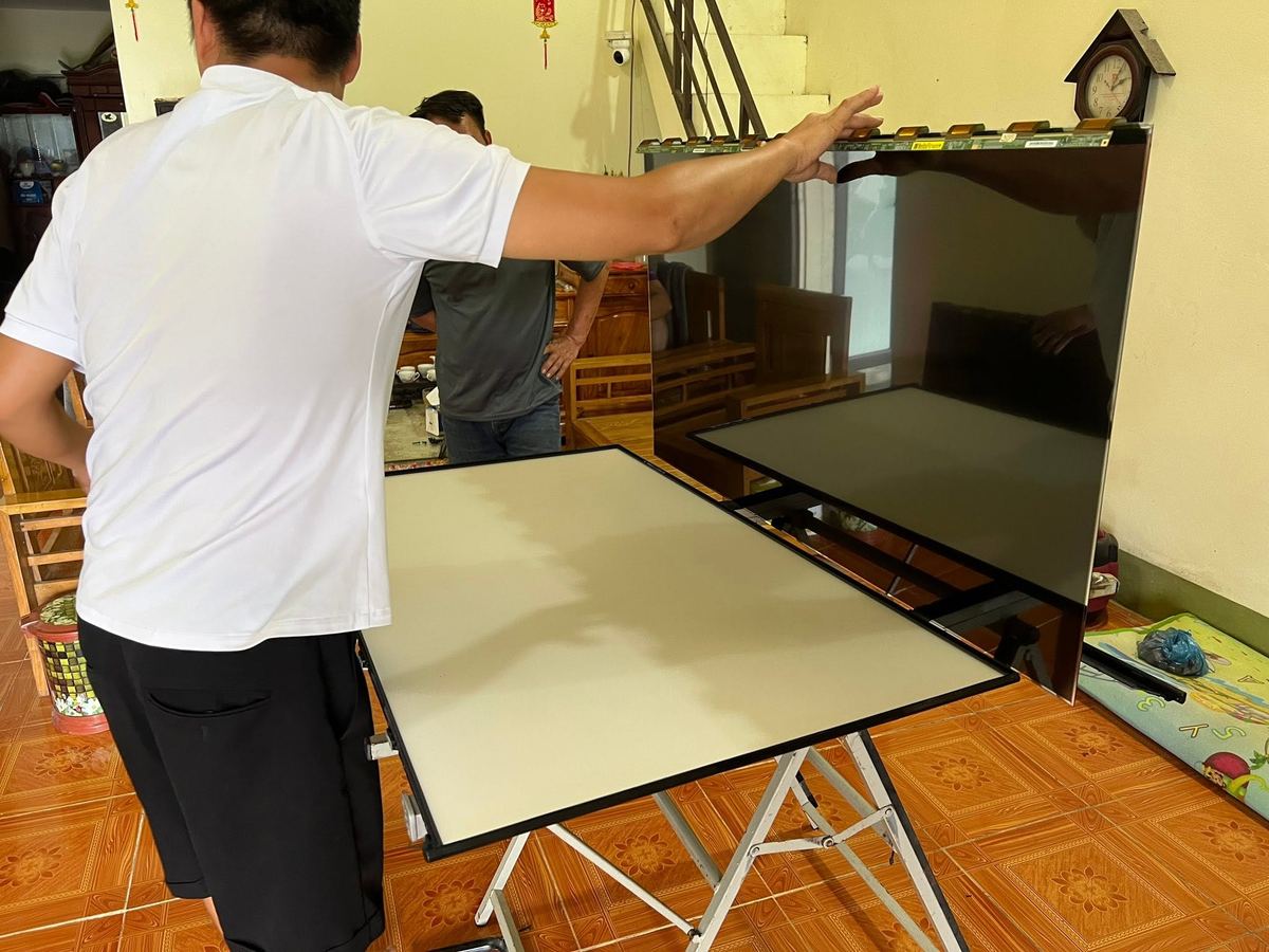 Kỹ thuật viên thay màn hình tivi tại nhà khách